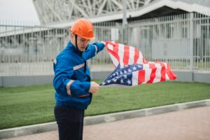 a patriontic american male worker holding usa national flag outdoors